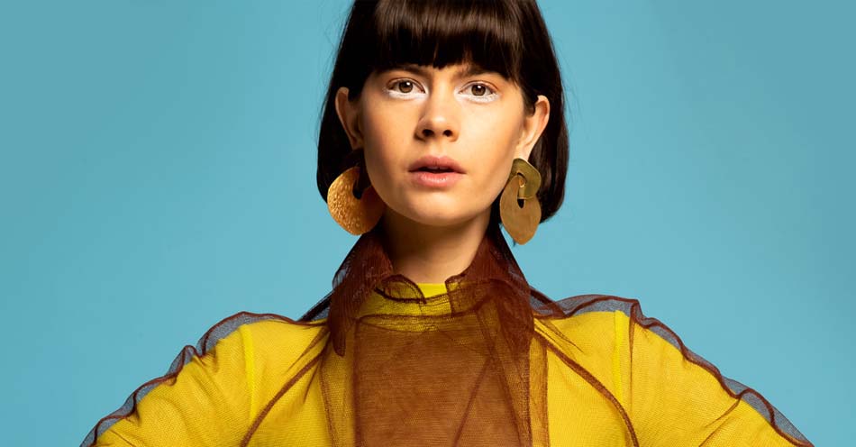 Image description: Model wears Kirsten Goss Long Island earrings. Kirsten Goss creates award-winning and internationally acclaimed fine jewelry with an international influence. Her jewelry, necklaces, earrings, bracelets and rings are available at Sarza