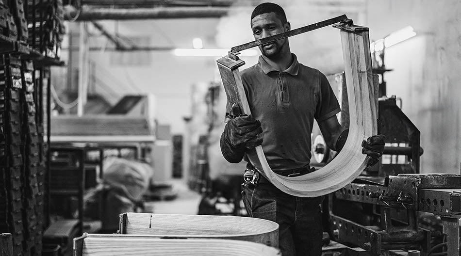 An artisan creating Woodbender chairs and seating. Woodbender dining chairs and bar stools are available via Sarza furniture store in Rye, New York.