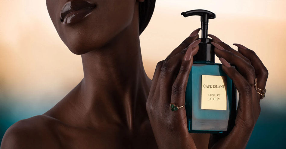 A woman holding a Cape Island luxury body lotion. Cape Island candles, body and bath products and home fragrances are available at Sarza home goods and furniture store in Rye New York