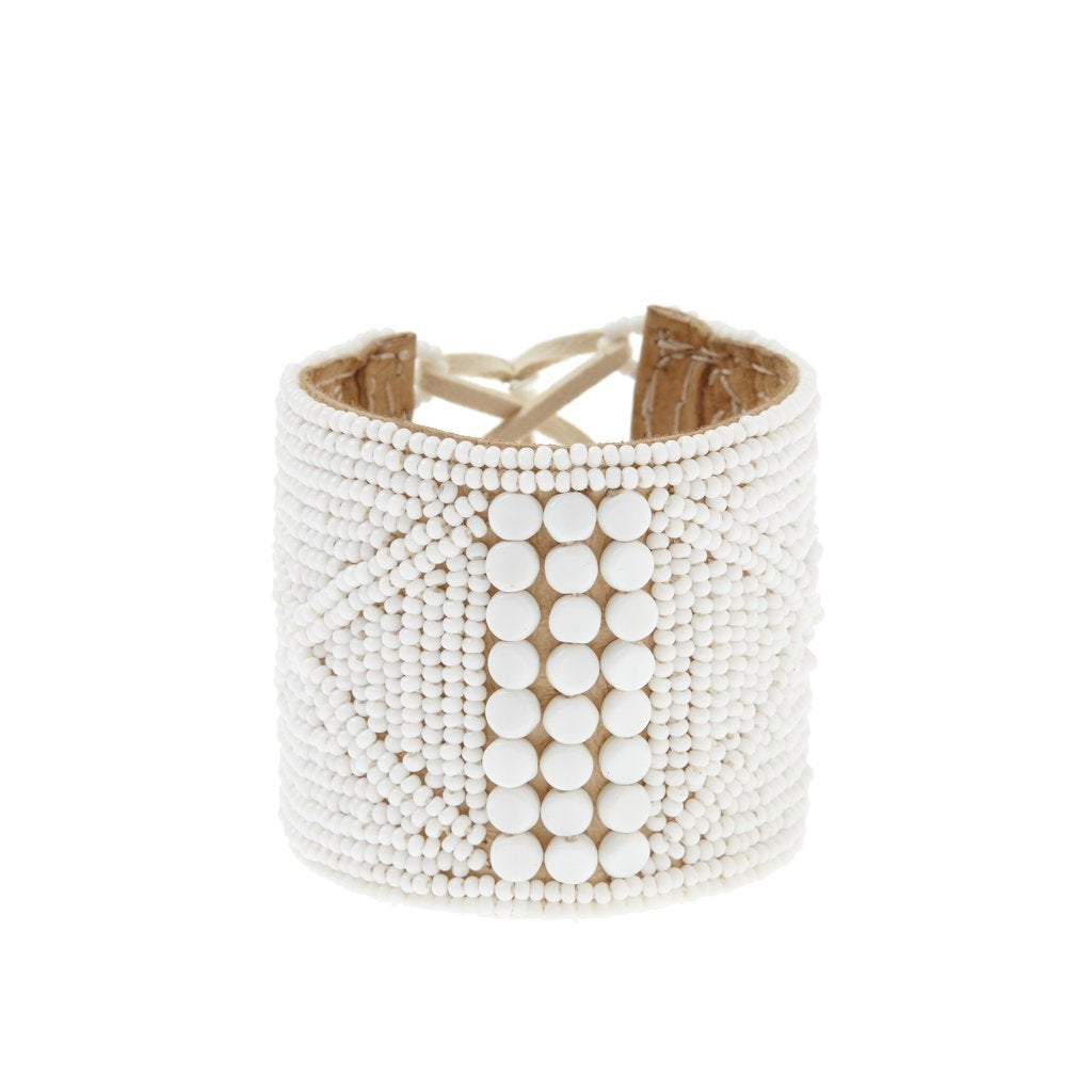 LEATHER BRACELET CUFF BY SIDAI DESIGNS JEWELRY. An intricately beaded leather bracelet from our Sipolio collection. This collection shares the journey of boyhood to warriorhood of a young Maasai male, who wears black and adorns himself with white beaded jewelry and detailed face markings. 