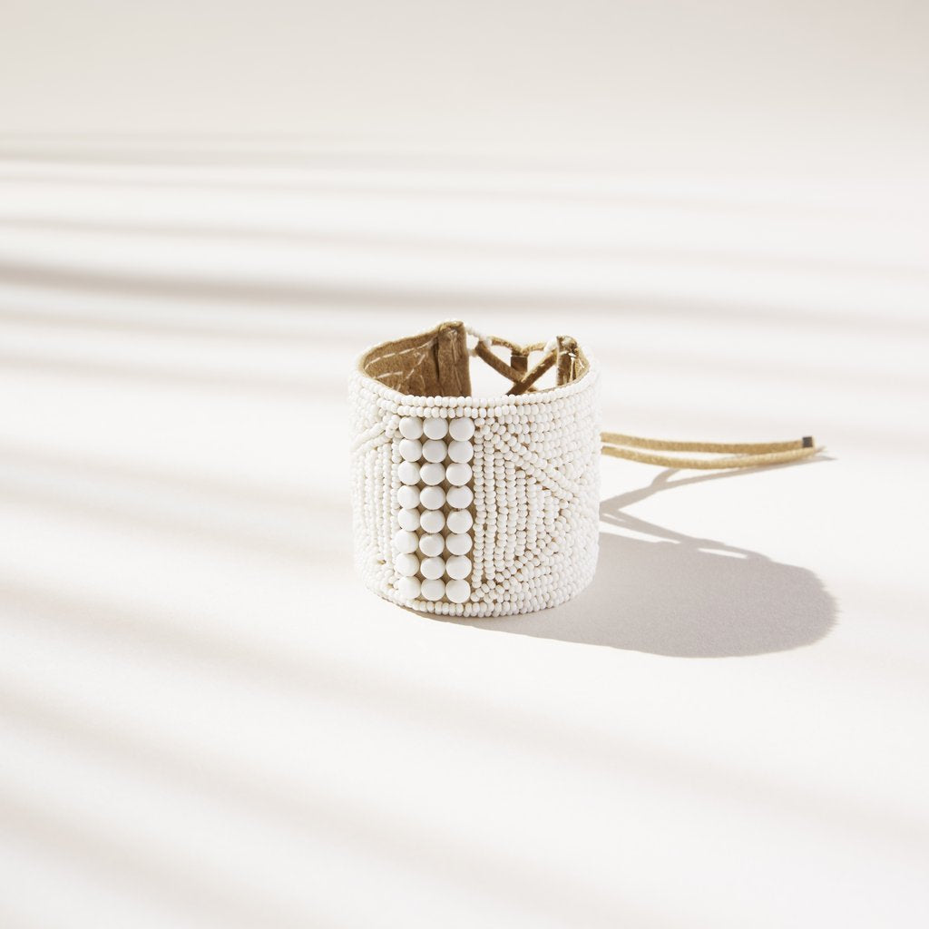 LEATHER BRACELET CUFF BY SIDAI DESIGNS JEWELRY. An intricately beaded leather bracelet from our Sipolio collection. This collection shares the journey of boyhood to warriorhood of a young Maasai male, who wears black and adorns himself with white beaded jewelry and detailed face markings. 