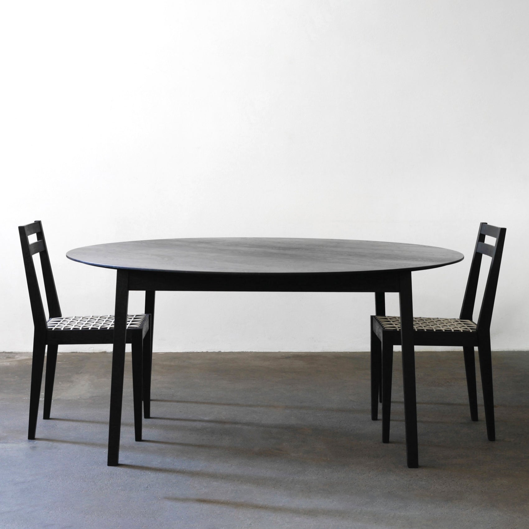 Tapered round table Ash charcoal with riempie chairs.jpg