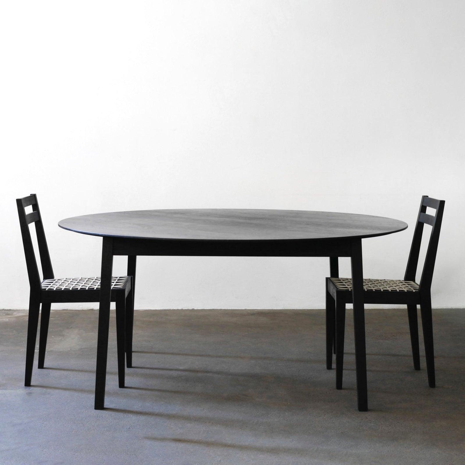 Tapered round table Ash charcoal with riempie chairs.jpg